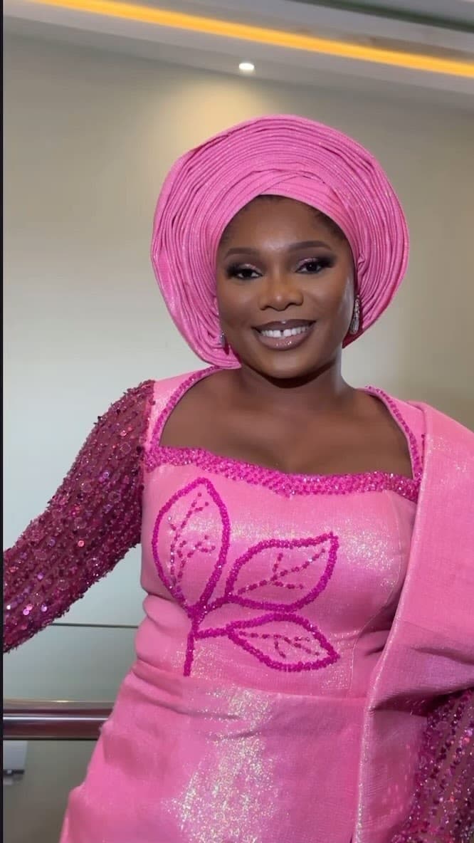 Vivian, a traditional bride in fuchsia with a pink gele and glowing bridal glam